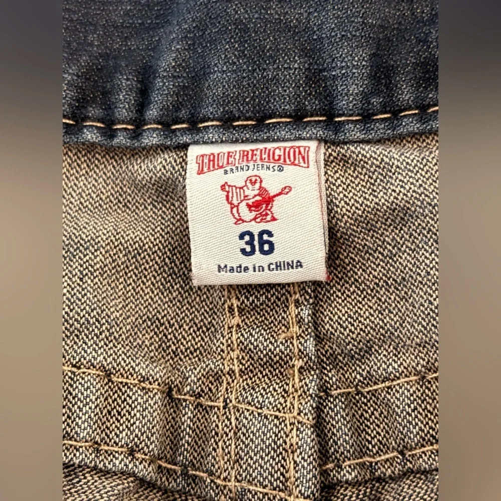 True Religion jeans feature a dark wash and bold signature stitching. Skinny